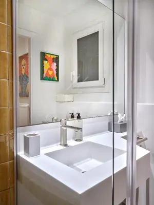 a white bathroom with a sink and a mirror at 30one Kolonaki Apartment in Athens