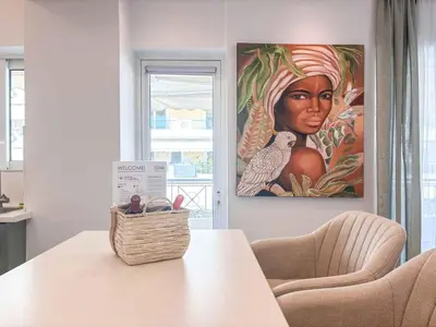 a table with a basket and a painting on the wall at Boho Flat in Glyfada Center in Athens
