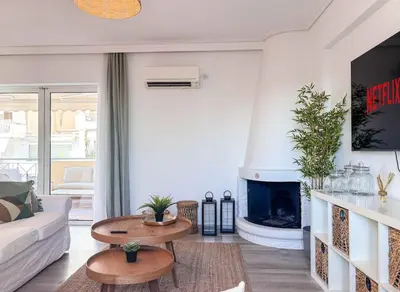 a living room with a couch and a fireplace at Boho Flat in Glyfada Center in Athens
