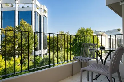 a balcony with two chairs and a table and a building at Gnamma Hotel in Athens