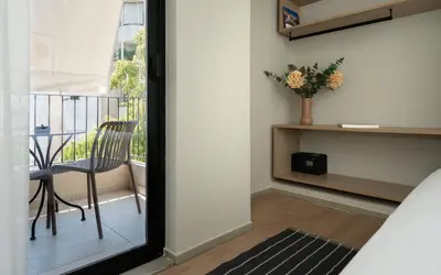 a room with a balcony with a chair and a table at Gnamma Hotel in Athens
