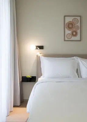 a bedroom with a white bed with white pillows at Gnamma Hotel in Athens