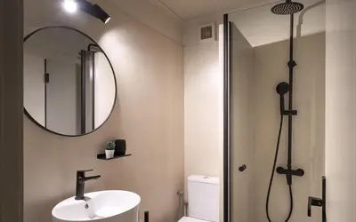a bathroom with a sink and a shower with a mirror at Gnamma Hotel in Athens