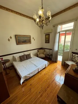 a bedroom with a bed and a chandelier at Neoclassical Athenian mansion in Athens