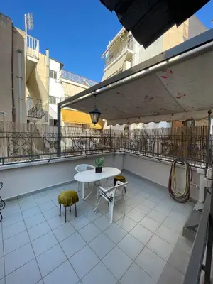a patio with a table and chairs on a balcony at Neoclassical Athenian mansion in Athens