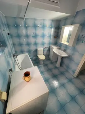 a blue tiled bathroom with a toilet and a sink at Neoclassical Athenian mansion in Athens