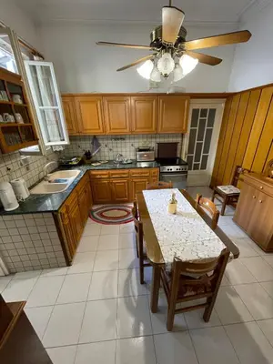 a kitchen with a table and a ceiling fan at Neoclassical Athenian mansion in Athens
