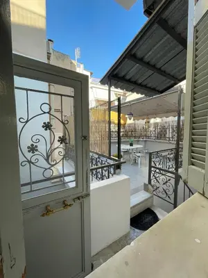 an open door to a balcony with tables and chairs at Neoclassical Athenian mansion in Athens