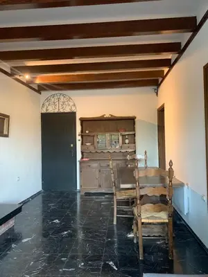 a room with a table and two chairs in it at Traditional Apartment in Varkiza in Vari