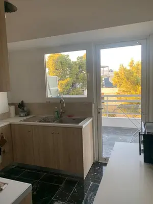 a kitchen with a sink and a window at Traditional Apartment in Varkiza in Vari