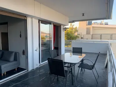 a patio with a table and chairs on a balcony at Traditional Apartment in Varkiza in Vari