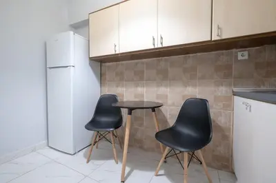 a kitchen with two chairs and a table and a refrigerator at Petralona Hideaway - Comfort for 4 by ΜΡS in Athens