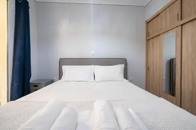 a bedroom with a bed with white sheets and pillows at Petralona Hideaway - Comfort for 4 by ΜΡS in Athens