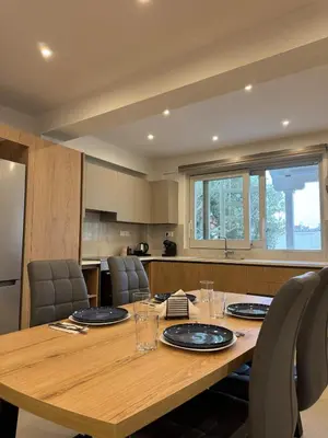 a large wooden table in a kitchen with chairs at East Side of Acropolis in Athens