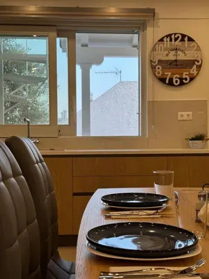 a dining room table with a clock on the wall at East Side of Acropolis in Athens