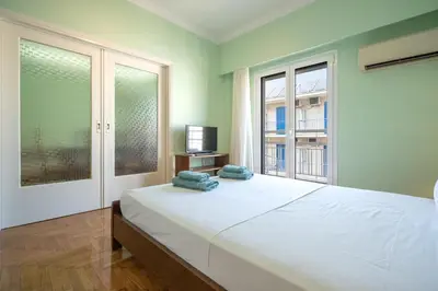 a bedroom with a large white bed and a television at Metaxourgeio Metro Apartment-Comfort for 3 by ΜΡS in Athens