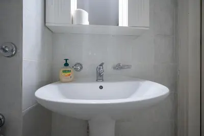 a bathroom sink with a bottle of soap on it at Metaxourgeio Metro Apartment-Comfort for 3 by ΜΡS in Athens