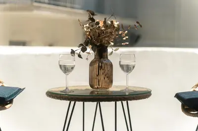 a table with two wine glasses and a vase with flowers at Skyline Spa Athens 010 in Athens
