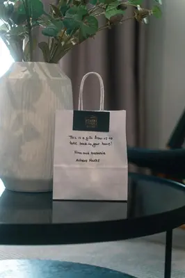 a paper bag sitting on a table next to a vase at Skyline Spa Athens 010 in Athens