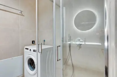 a bathroom with a washing machine and a shower at Skyline Spa Athens 010 in Athens