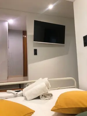 a bedroom with a bed with a tv on the wall at Aiolos Sea loft central market Palaio Faliro in Athens