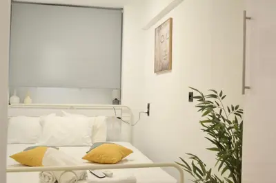 a bedroom with a bed and a clock on the wall at Aiolos Sea loft central market Palaio Faliro in Athens