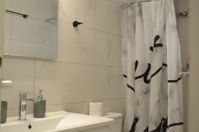 a bathroom with a sink and a shower curtain at Aiolos Sea loft central market Palaio Faliro in Athens