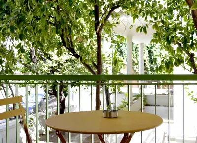 a small table on a balcony with a tree at Aiolos Sea loft central market Palaio Faliro in Athens