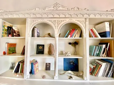 a white book shelf with books on it at Sunny room in the heart of the city in Athens