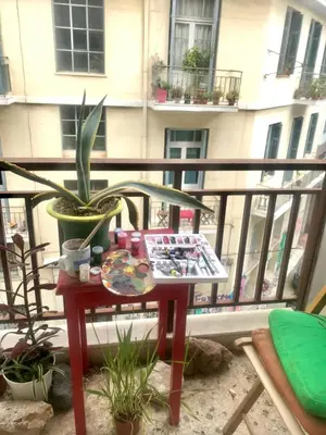 a table on a balcony with a plant at Sunny room in the heart of the city in Athens