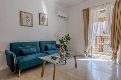 a living room with a blue couch and a table at Bright 2BR Apt, Athens Base Near Sea & City in Athens