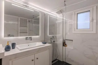 a white bathroom with a sink and a shower at Bright 2BR Apt, Athens Base Near Sea & City in Athens