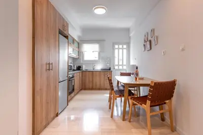 a kitchen with a table and chairs in a room at Bright 2BR Apt, Athens Base Near Sea & City in Athens