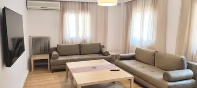 a living room with two couches and a coffee table at Family apartment in Acropolis with roof garden in Athens