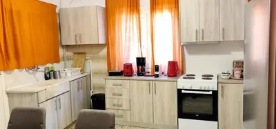 a kitchen with wooden cabinets and a stove top oven at Family apartment in Acropolis with roof garden in Athens