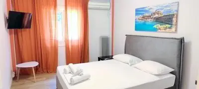 a bedroom with a white bed and a tv at Family apartment in Acropolis with roof garden in Athens