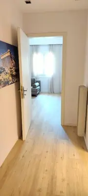 an open door to a living room with a couch at Family apartment in Acropolis with roof garden in Athens