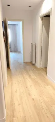 an empty room with a wooden floor and an open door at Family apartment in Acropolis with roof garden in Athens