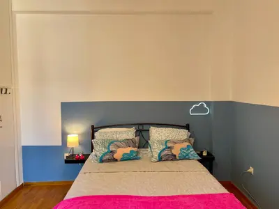 a bedroom with a bed with a pink blanket at Acropolis Happy Place in Athens