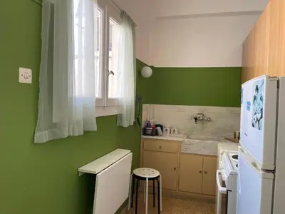 a kitchen with green walls and a white refrigerator at Acropolis Happy Place in Athens