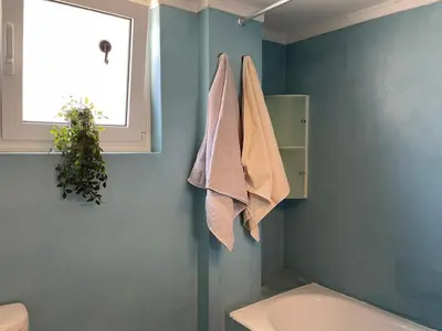 a bathroom with a sink and towels hanging on the wall at Acropolis Happy Place in Athens