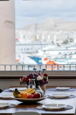 a table with a plate of fruit and a view of a harbor at Piraeus PortView Apt in Piraeus