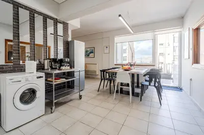 a kitchen with a washing machine and a table with chairs at Piraeus PortView Apt in Piraeus