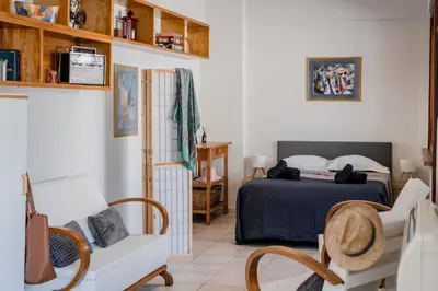 a bedroom with a bed and chairs in a room at Piraeus PortView Apt in Piraeus