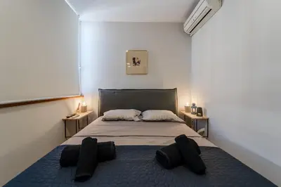 a bedroom with a bed with black pillows on it at Piraeus PortView Apt in Piraeus