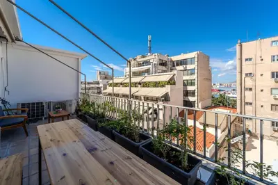 a balcony with plants and a view of buildings at Piraeus PortView Apt in Piraeus