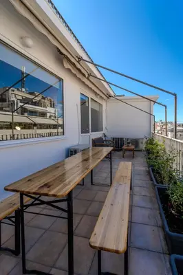 a patio with wooden benches on a building at Piraeus PortView Apt in Piraeus