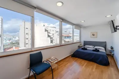 a bedroom with a bed and a large window at Piraeus PortView Apt in Piraeus