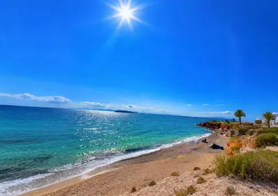 a beach with palm trees and the sun in the sky at sea soul house in Athens