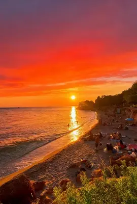 a sunset on a beach with people on it at sea soul house in Athens
